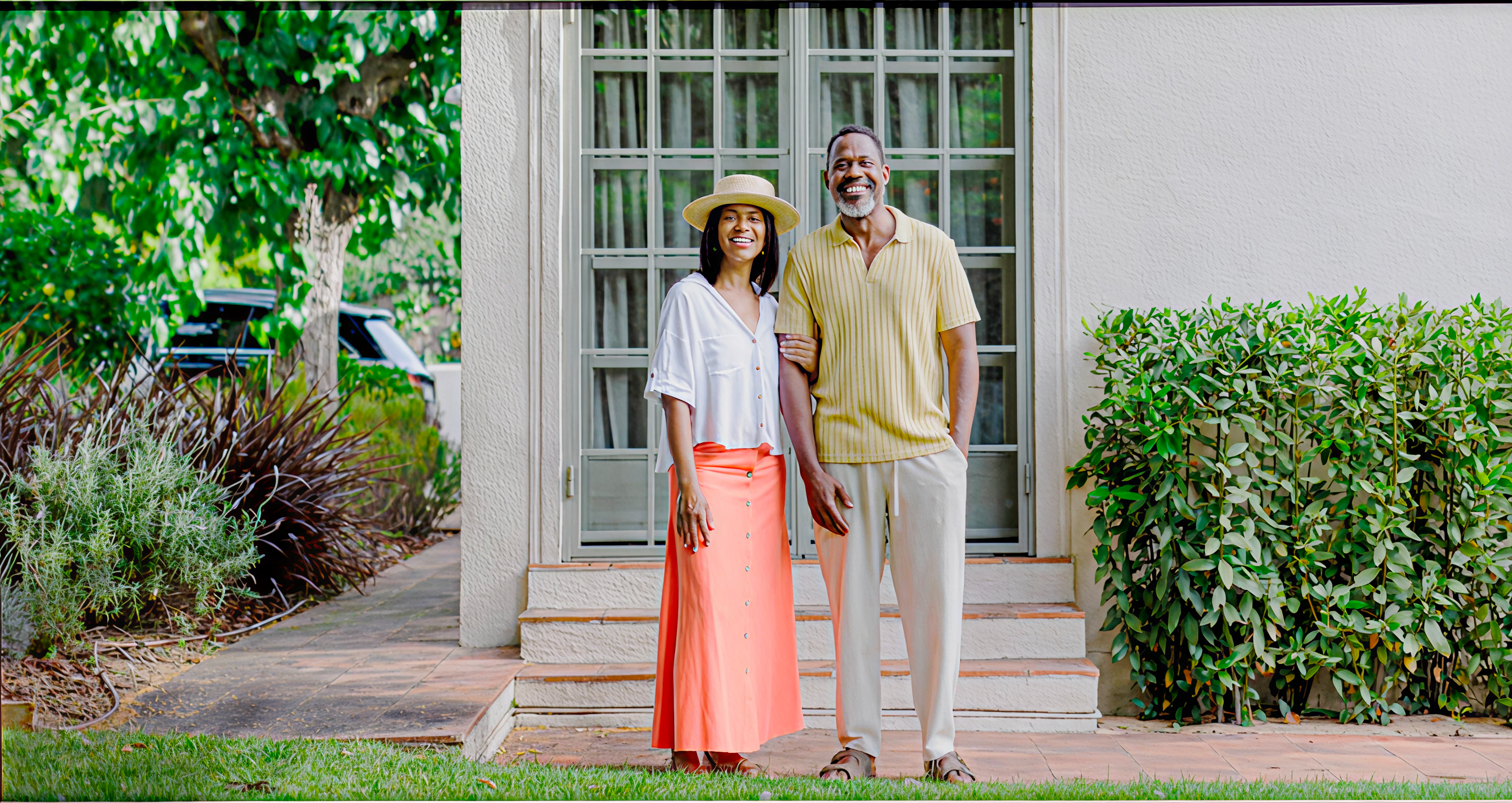 A couple in front of their home
